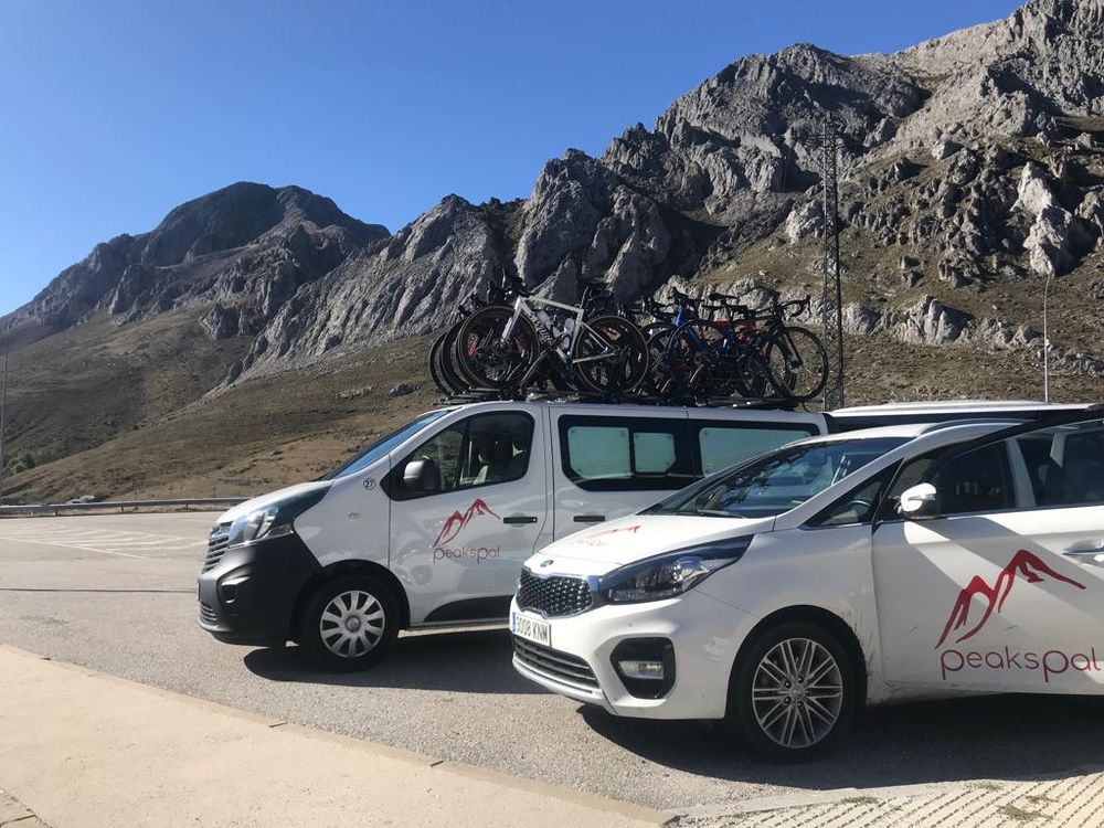 Two PeaksPal support vehicles parked below limestone peaks in northern Spain