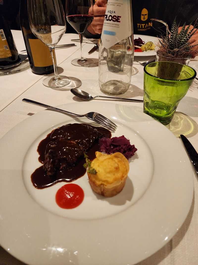 A plated dinner course with wine on a restaurant table