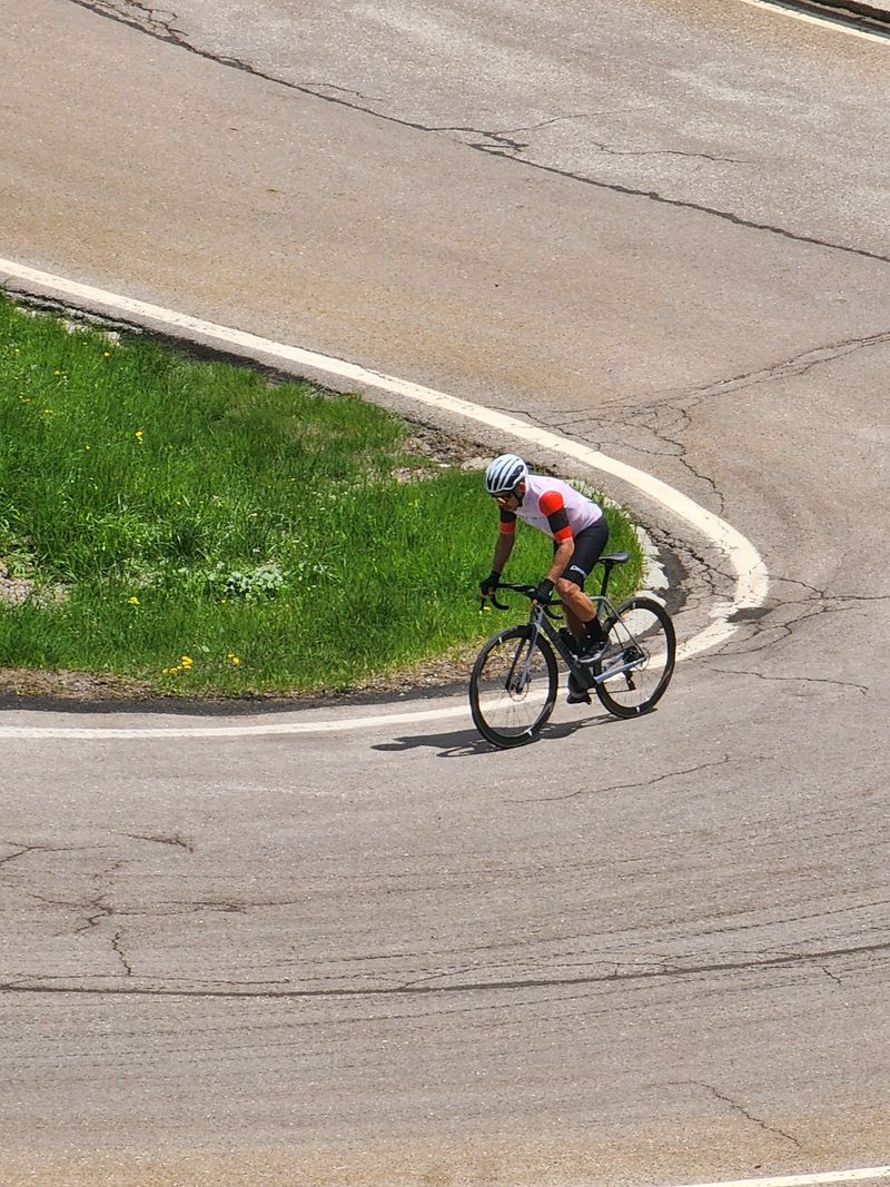 A lone rider rounding a hairpin seen from above
