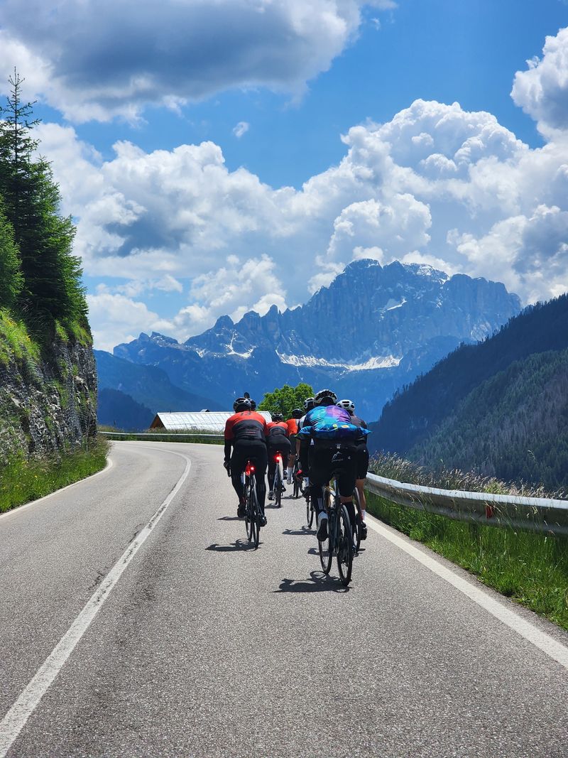 Riders heading toward the Dolomite peaks on an open valley road