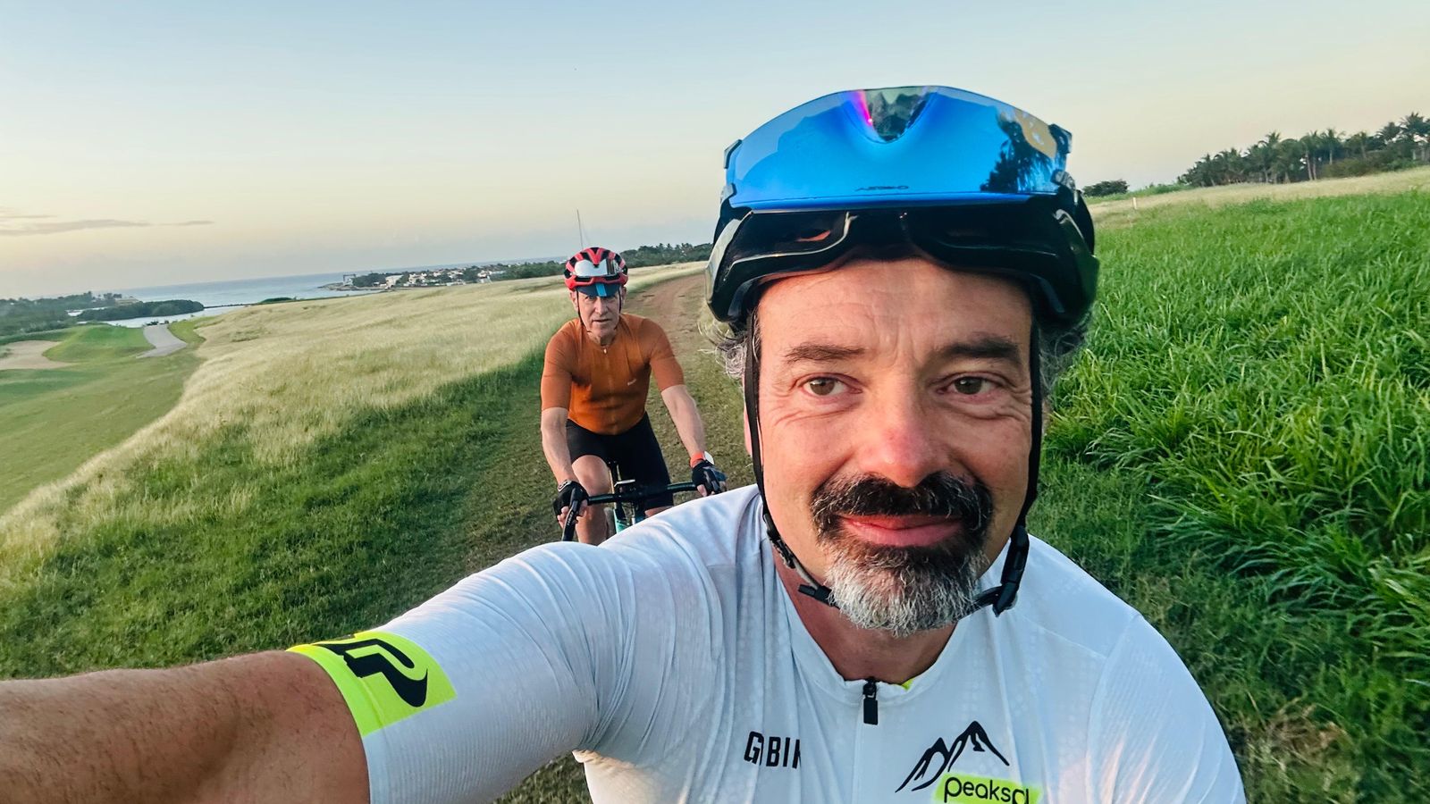 Umberto Pitzalis riding on a coastal trail with a second rider behind him